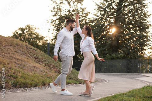 Lovely couple dancing together outdoors at sunset