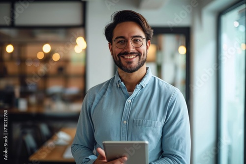 Smiling busy young latin business man manager using tablet computer, happy hispanic businessman executive looking at camera holding tab working standing in office, Generative AI