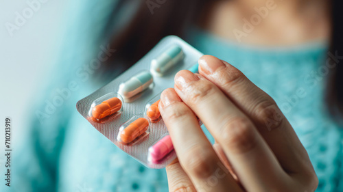  A woman holds a package of antibiotic capsules in her hand  symbolizing careful health care and disease prevention.