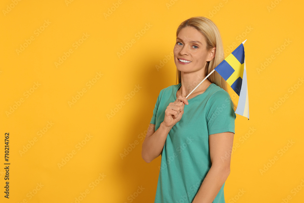 Woman with flag of Sweden on yellow background, space for text Woman with flag of Sweden on yellow background, space for text