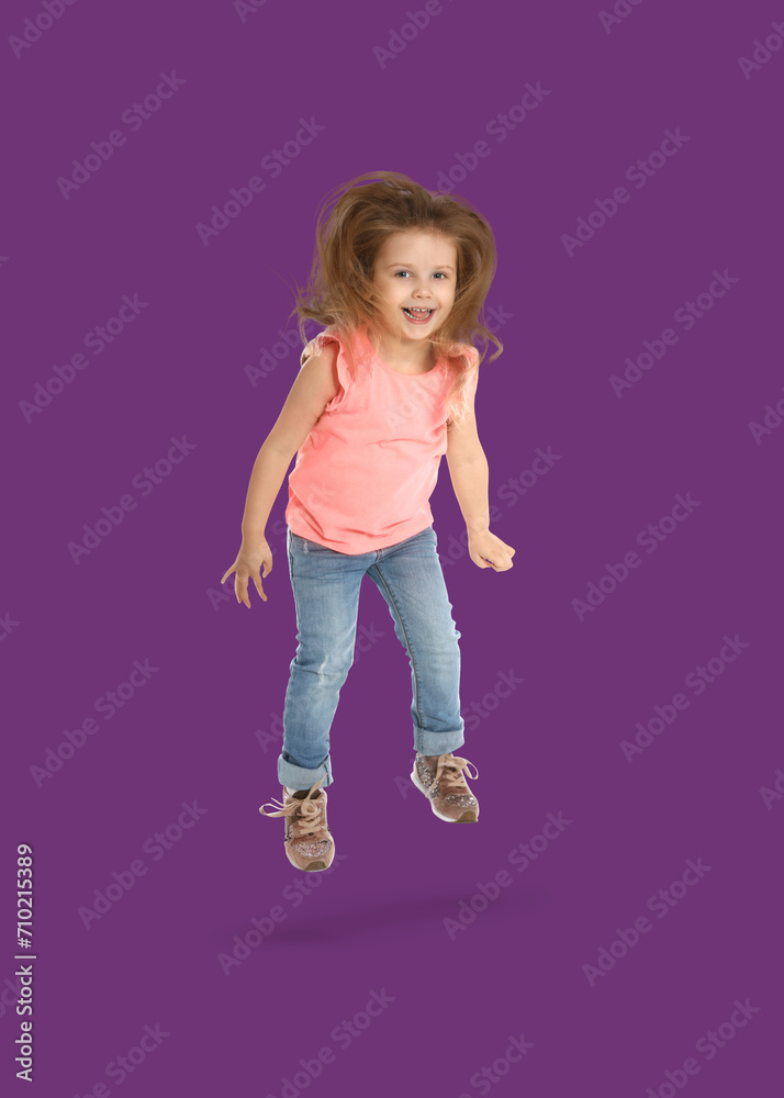 Happy cute girl jumping on purple background Happy cute girl jumping on purple background