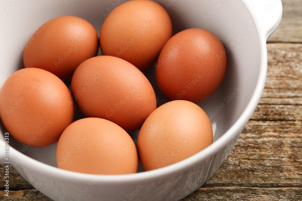 Unpeeled boiled eggs in saucepan on old wooden table, closeup Unpeeled boiled eggs in saucepan on old wooden table, closeup