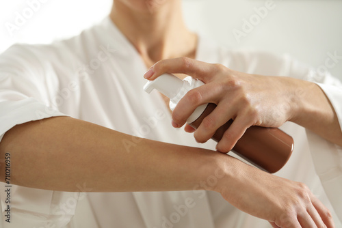 Woman applying self-tanning product onto arm, closeup