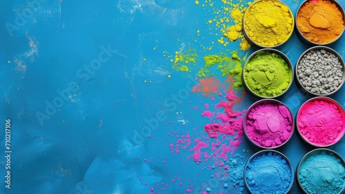 Vibrant colored powders on blue background with bowls