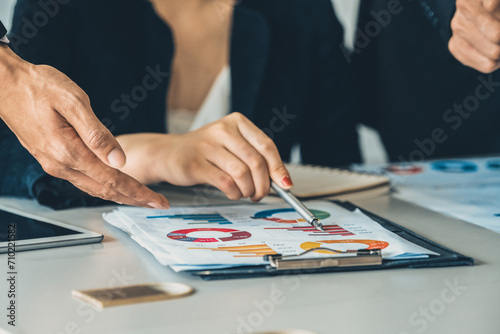 Businessman and businesswoman in meeting working with many financial statement document on desk. Concept of busy business profit analysis and brainstorm. Close up shot at people hands and papers. uds