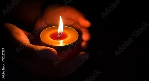 The candle is lit in a glass held by a beautiful woman in black. Isolated on the concept of saving the earth's energy. Earth hour