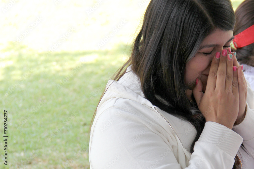 Latin adult woman smells essential oils from her hands as aromatherapy in a holistic ceremony to relax the body and calm the nerves, ritual for introspection Latin adult woman smells essential oils from her hands as aromatherapy in a holistic ceremony to relax the body and calm the nerves, ritual for introspection