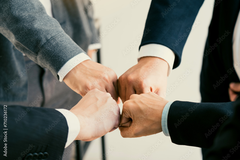 Teamwork, team building, responsibility and equal opportunities. Hand holding together bumping fists in circle as unity symbol.