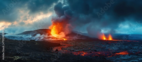 Daytime volcanic eruption on Reykjanes peninsula with lava shooting from Fagradalsfjall volcano crater in Icelandic Geopark, accompanied by clouds and steam in the sky.