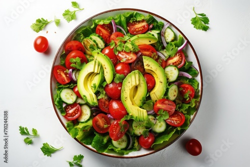 Top view of a fresh salad with tomatoes and avocado on a light background