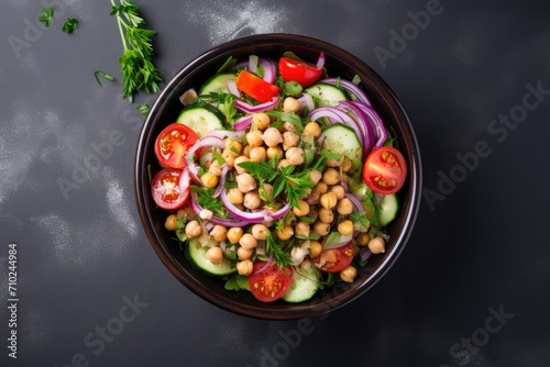 Top view of vegetarian chickpea salad in a paper bowl with tomatoes cucumber red onion cress salad and arugula High in protein and fiber zero waste dishware