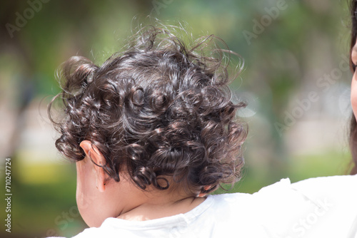 Toddler curly hair kid in a park