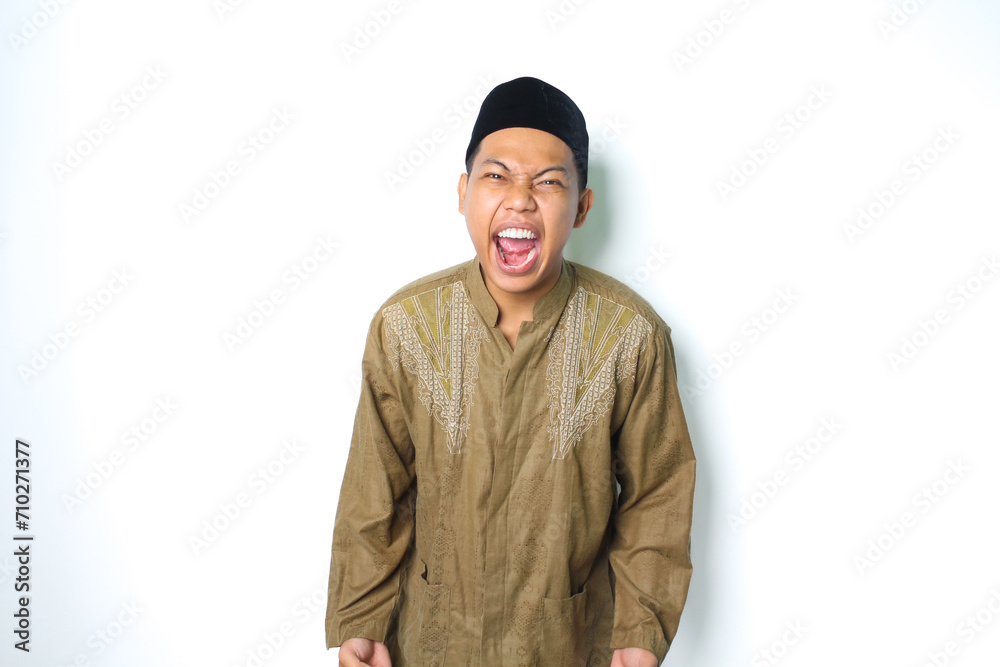 angry asian muslim male screaming with grabbing hand looking at camera isolated on white background angry asian muslim male screaming with grabbing hand looking at camera isolated on white background