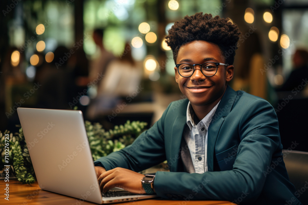 African-American kid dressed as a business man sitting in office chair. Teenager smiling sitting in the office. Working student. Learning from young age, intellectual growth African-American kid dressed as a business man sitting in office chair. Teenager smiling sitting in the office. Working student. Learning from young age, intellectual growth