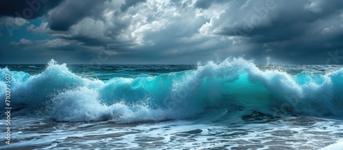 Intense waves in vibrant turquoise crash under cloudy sky.