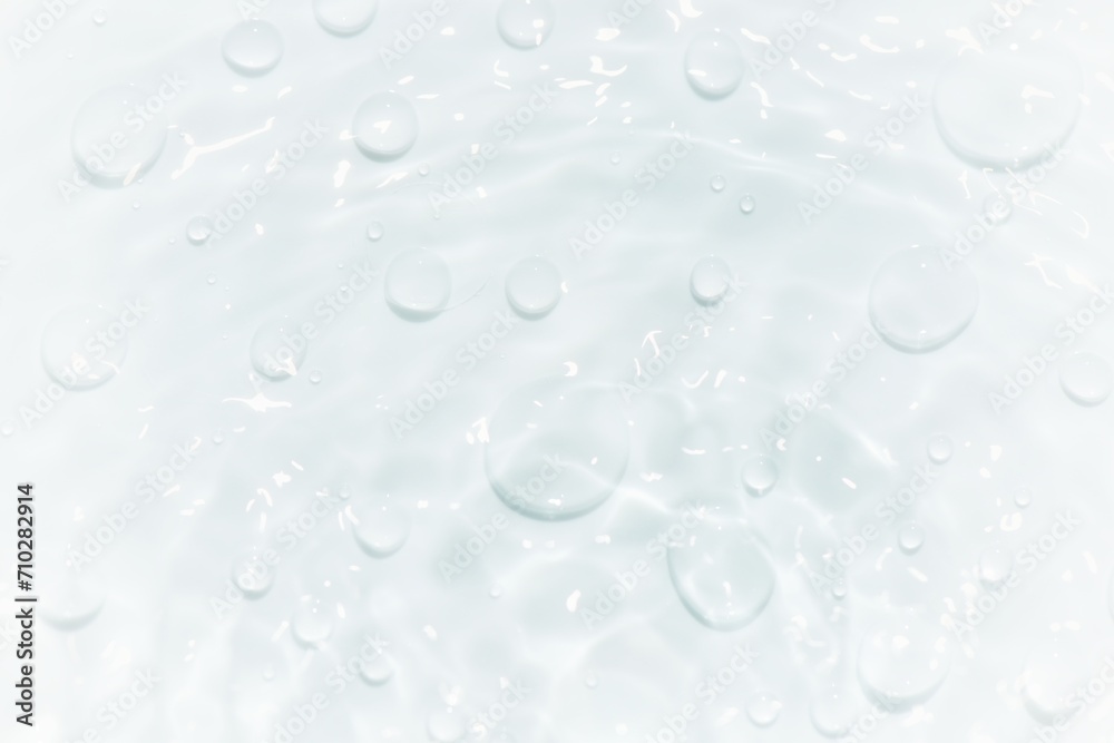 Bluewater waves on the surface ripples blurred. Defocus blurred transparent blue colored clear calm water surface texture with splash and bubbles. Water waves with shining pattern texture background. Bluewater waves on the surface ripples blurred. Defocus blurred transparent blue colored clear calm water surface texture with splash and bubbles. Water waves with shining pattern texture background.