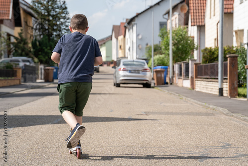 Boy rides a scooter on the street