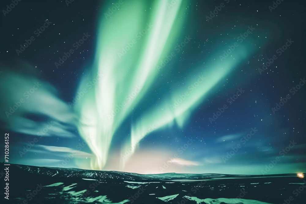 A stunning display of aurora borealis lights up the night sky above a snowy, serene landscape.