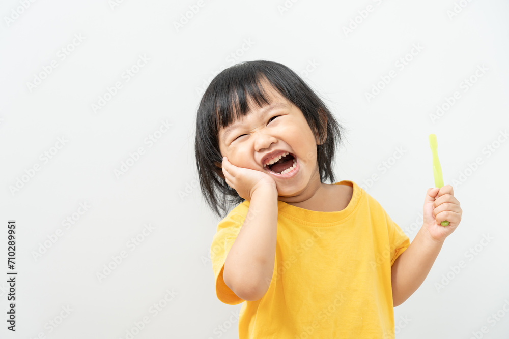 little asian girl presses hand to cheek, suffers from pain in tooth. Teeth decay, dental problems, child emotions and facial expression, oral health care, reducing sweets, fluorine coating little asian girl presses hand to cheek, suffers from pain in tooth. Teeth decay, dental problems, child emotions and facial expression, oral health care, reducing sweets, fluorine coating