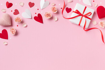 Valentine day or mother day festive composition with gift or present box, rose flowers and pink red hearts on pastel background top view. Flat lay greeting card..