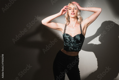 Stunning Blonde Woman with Mesmerizing Blue Eyes Strikes a Pose in Studio with Creative Spotlight Effects - A Visual Delight!