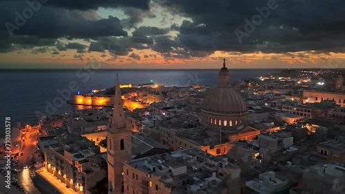 Aerial morning view of Valletta with city lights in Malta. Flying over Valletta old town at sunrise, Malta. UHD, 4K photo