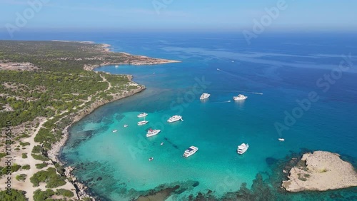 Flying over yachts with tourists in the blue lagoon on the west coast of Cyprus. Turquoise lagoon water in AKAMAS Nature Reserve Park, Cyprus. Aerial shot, 4K photo