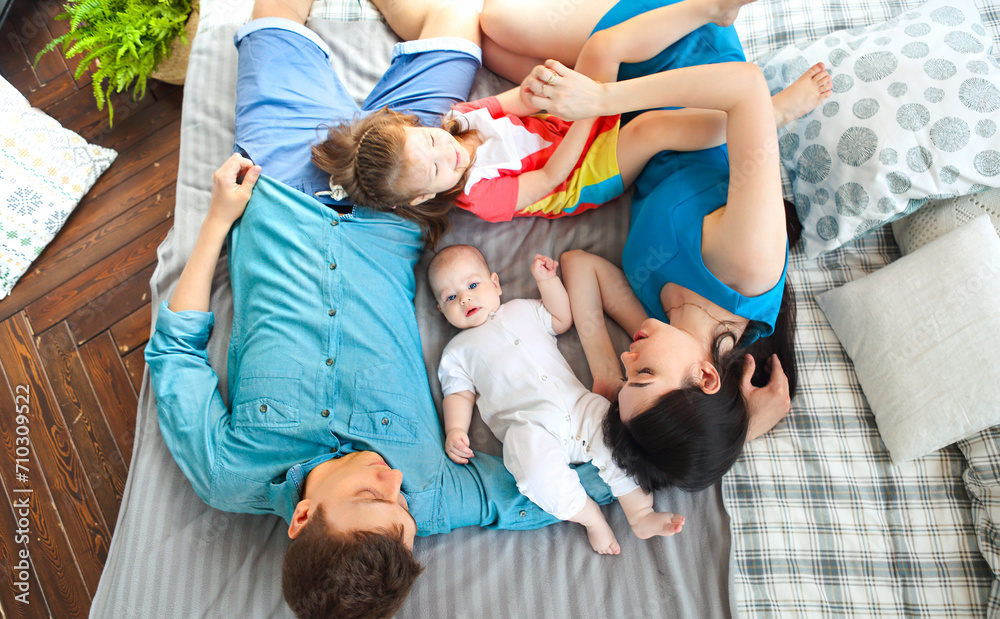 Happy smiling caucasian family lying on the bed