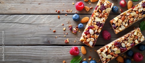 Almond and fruit energy bars on wooden table, top view, copy space.