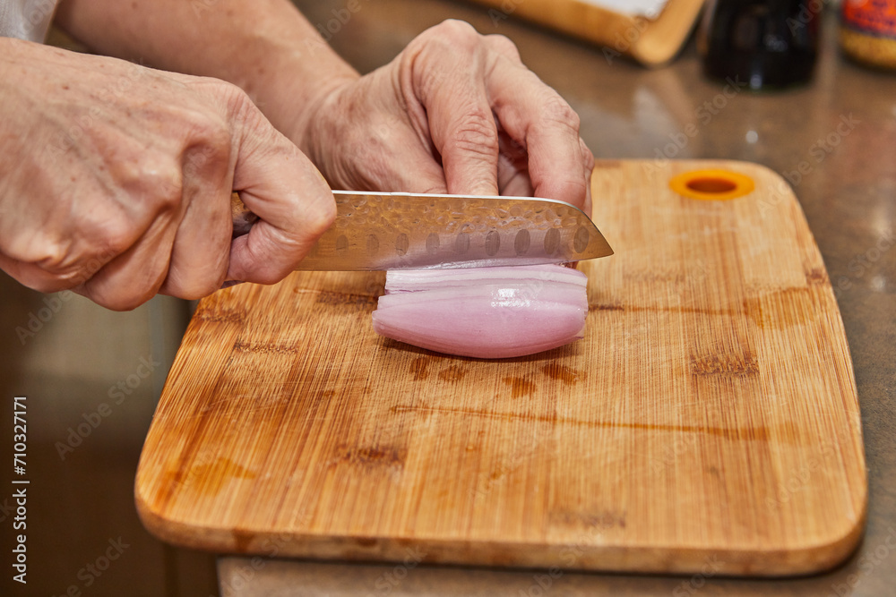 Slicing Fresh Shallots on Wooden Cutting Board with Kitchen Knife Slicing Fresh Shallots on Wooden Cutting Board with Kitchen Knife