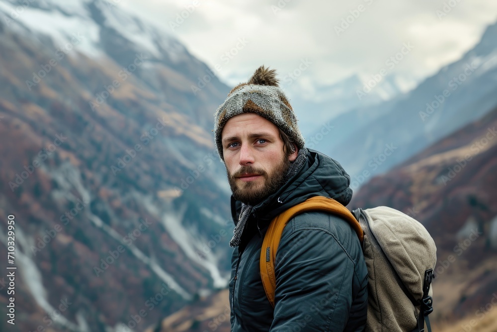 Outdoor-inspired studio portrait of a European man with a rugged look, isolated on a mountainous background