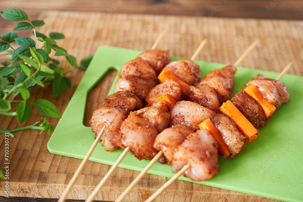Chicken breast skewers with carrots on a green cutting board. Diet meat.