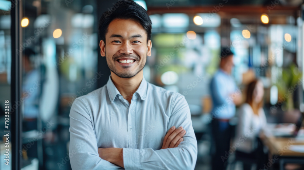 Portrait of a handsome smiling asian businessman boss standing in his modern business company office. Portrait of a handsome smiling asian businessman boss standing in his modern business company office.