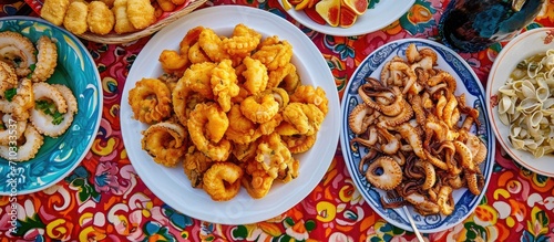 Sicilian street food showcased at Palermo market, featuring calamari, octopus, and fried fish on a vibrant tablecloth.