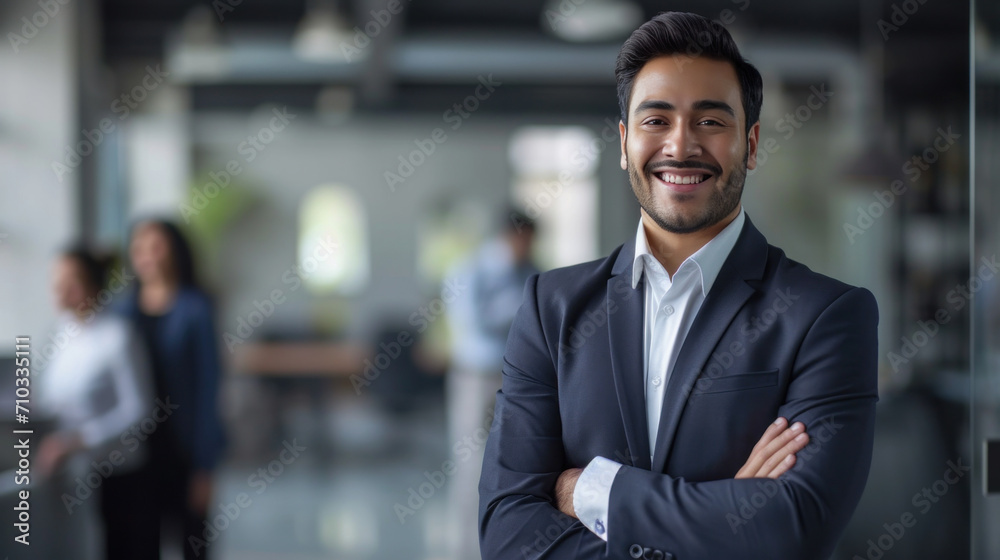 Portrait of a handsome smiling asian indian businessman boss standing in his modern business company office.