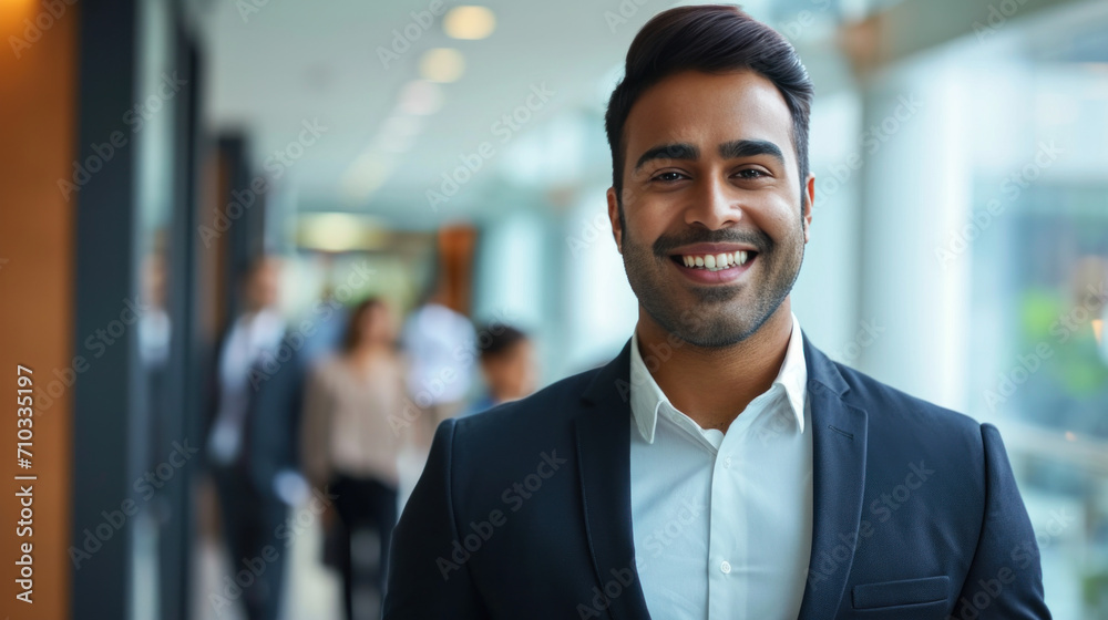 Portrait of a handsome smiling asian indian businessman boss standing in his modern business company office. Portrait of a handsome smiling asian indian businessman boss standing in his modern business company office.