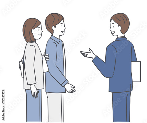 若い夫婦に案内をするビジネスマン