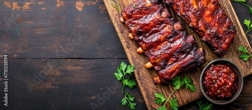 Top view of barbecue ribs on rustic board with fruit relish and space for notes photo