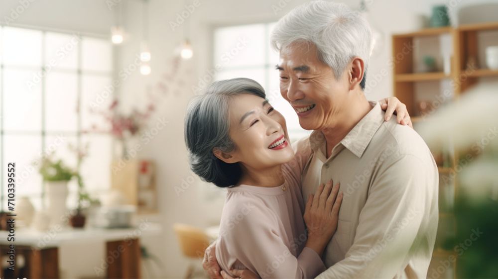きれいなリビングで笑顔で抱き合うシニア夫婦 Senior couple hug in living room きれいなリビングで笑顔で抱き合うシニア夫婦 Senior couple hug in living room