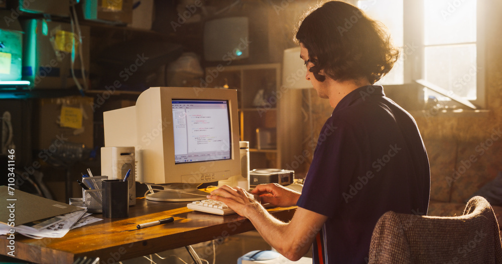 Caucasian Male Software Engineer Programming on Old Desktop Computer In Retro Garage. Focused Man Starting Fintech Startup Company In Nineties. Coding Innovative Online Service At Home.