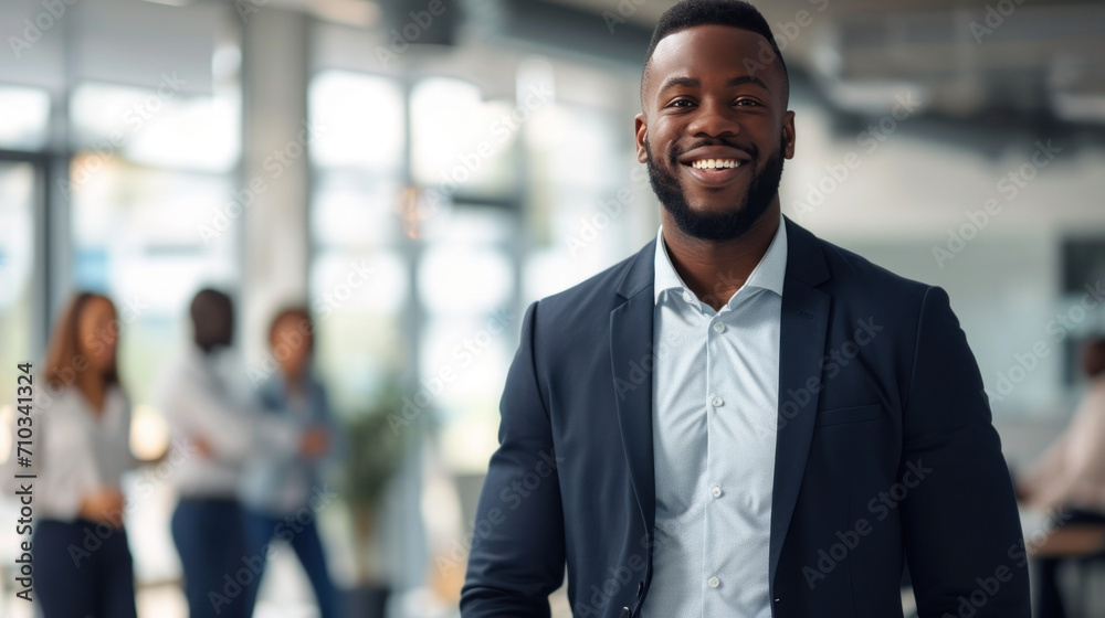 Portrait of a handsome smiling black businessman boss standing in his modern business company office.