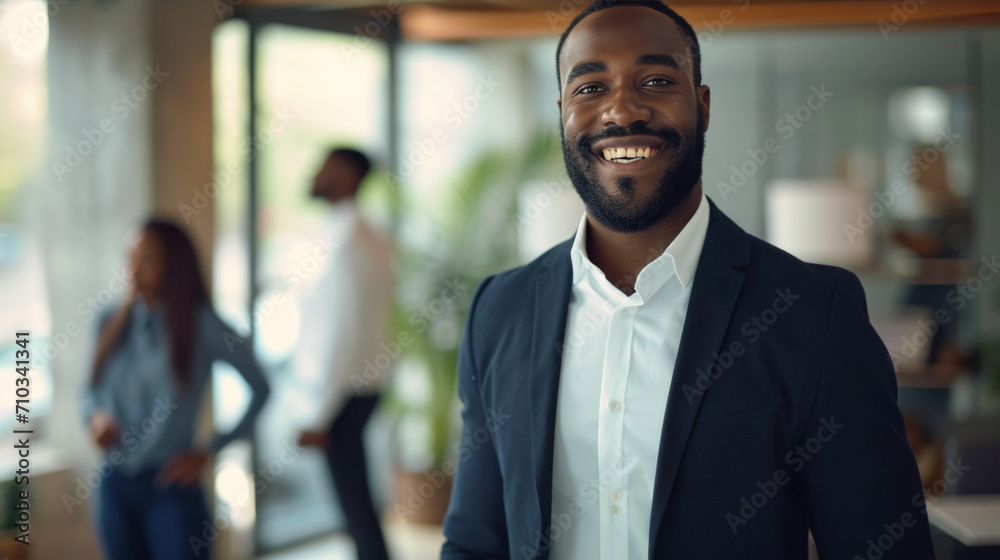 Naklejka premium Portrait of a handsome smiling black businessman boss standing in his modern business company office.