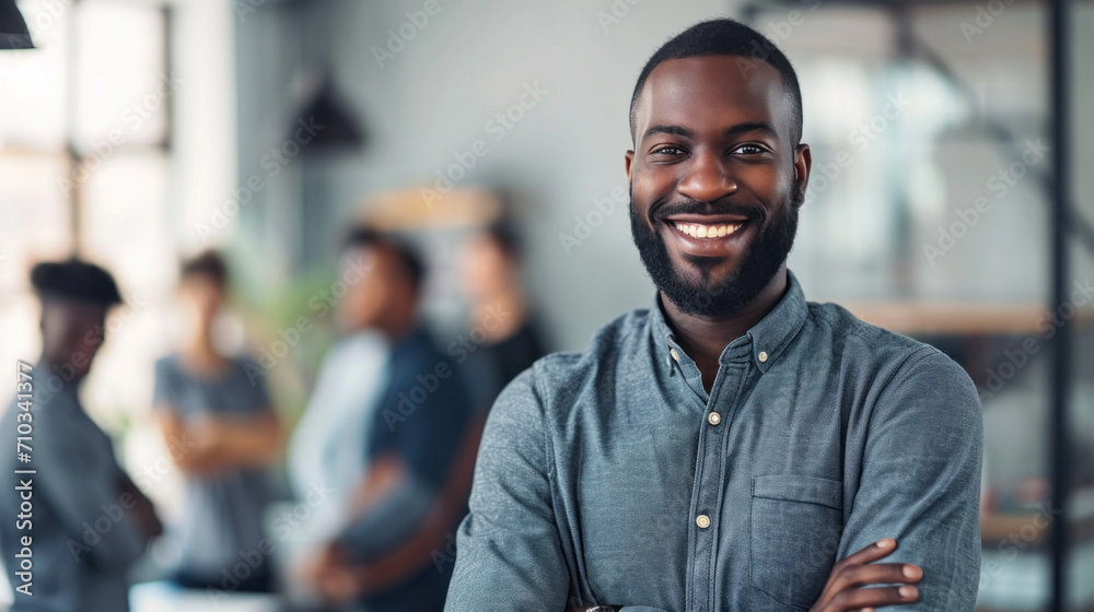 Portrait of a handsome smiling black businessman boss standing in his modern business company office.