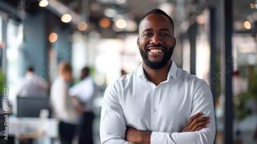 Portrait of a handsome smiling black businessman boss standing in his modern business company office. photo