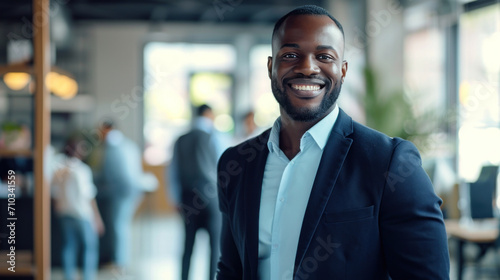 Portrait of a handsome smiling black businessman boss standing in his modern business company office. photo