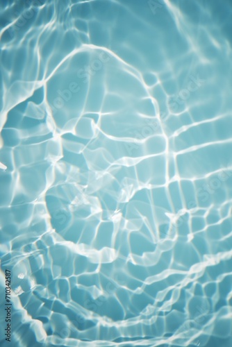 Bluewater waves on the surface ripples blurred. Defocus blurred transparent blue colored clear calm water surface texture with splash and bubbles. Water waves with shining pattern texture background.