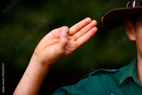 Photography Boy scout in uniform performs three finger salute