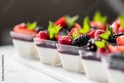 Vanilla Panna Cotta topped with mix berry fruit and mint photo