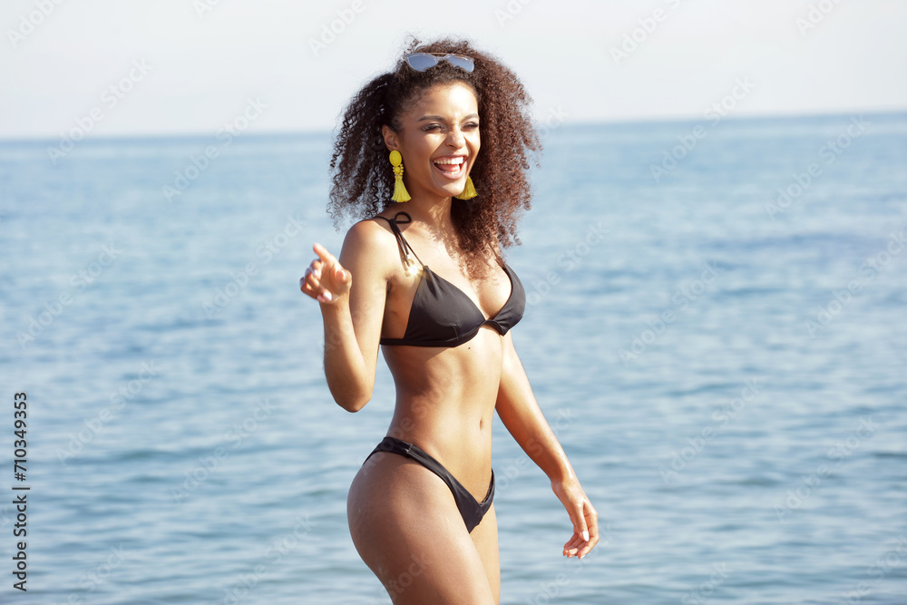 Happy smiling afro woman enjoying sun on the beach,