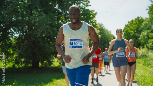 Portrait of a Black Athletic Male Running a Marathon in a City During the Day in Green Park Trail. Resilient and Dedicated Joggers Racing to the Finish Line, Pushing Through Tiredness